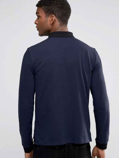 Close-up of a textured performance polo shirt. Fine stitching detail, breathable moisture-wicking fabric, a subtle blue hue.