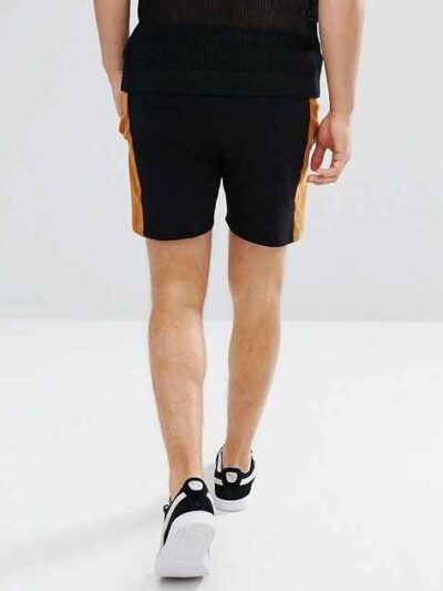 Lightweight drawstring beach shorts with vibrant print. Note fine stitching and soft, textured fabric. Summer casual wear. -