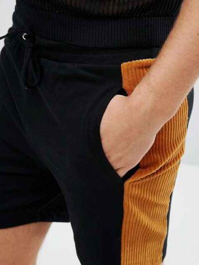 Lightweight drawstring beach shorts with vibrant print. Note fine stitching and soft, textured fabric. Summer casual wear. -
