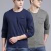 Close-up of a navy blue t-shirt with a white logo print. Cotton fabric texture, clean stitching detail. Short sleeve crew nec