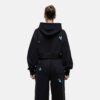 Women's tracksuit set. Close-up shows soft, brushed fleece texture. Heather grey top & matching bottoms, detailed stitching.