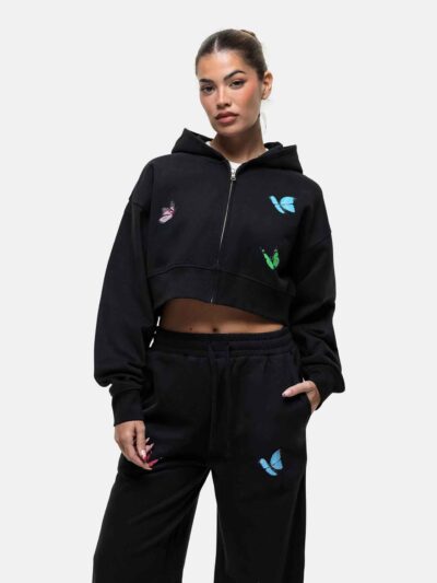 Women's tracksuit set. Close-up shows soft, brushed fleece texture. Heather grey top & matching bottoms, detailed stitching.