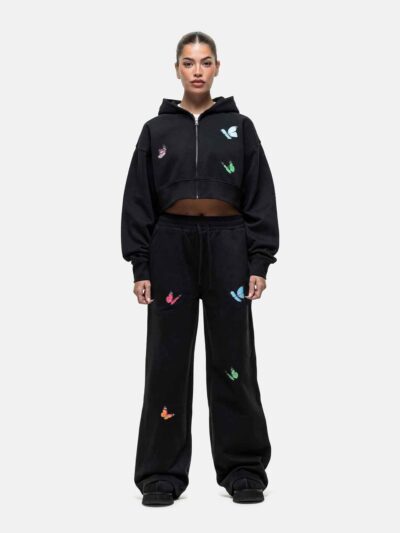 Women's tracksuit set. Close-up shows soft, brushed fleece texture. Heather grey top & matching bottoms, detailed stitching.