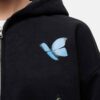 Women's tracksuit set. Close-up shows soft, brushed fleece texture. Heather grey top & matching bottoms, detailed stitching.