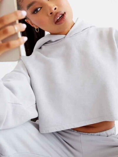 Woman's street style tracksuit. Embroidered logo detail. Soft, looped terry knit texture. Relaxed fit, neutral color tones. P