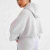 Woman's street style tracksuit. Embroidered logo detail. Soft, looped terry knit texture. Relaxed fit, neutral color tones. P