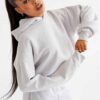 Woman's street style tracksuit. Embroidered logo detail. Soft, looped terry knit texture. Relaxed fit, neutral color tones. P