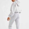 Woman's street style tracksuit. Embroidered logo detail. Soft, looped terry knit texture. Relaxed fit, neutral color tones. P