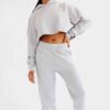 Woman's street style tracksuit. Embroidered logo detail. Soft, looped terry knit texture. Relaxed fit, neutral color tones. P