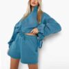 Women's two-piece tracksuit with vibrant all-over print. Soft, textured fabric. Detailed stitching visible on cuffs and waist