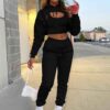 Women's two-piece tracksuit with vibrant all-over print. Soft, textured fabric. Detailed stitching visible on cuffs and waist