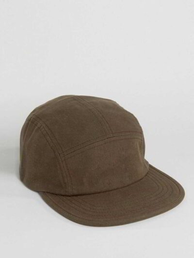 Close-up of a five-panel cap. Premium construction, tight stitching, possibly cotton twill. Adjustable snapback, green underv