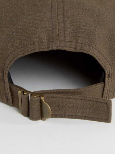 Close-up of a five-panel cap. Premium construction, tight stitching, possibly cotton twill. Adjustable snapback, green underv