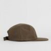Close-up of a five-panel cap. Premium construction, tight stitching, possibly cotton twill. Adjustable snapback, green underv