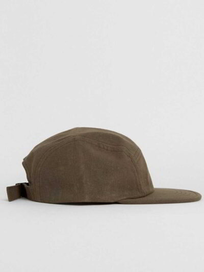 Close-up of a five-panel cap. Premium construction, tight stitching, possibly cotton twill. Adjustable snapback, green underv