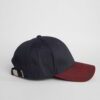 Close-up of a textured twill golf visor in navy with crisp white custom logo embroidery. Curved brim, detailed stitching, adj