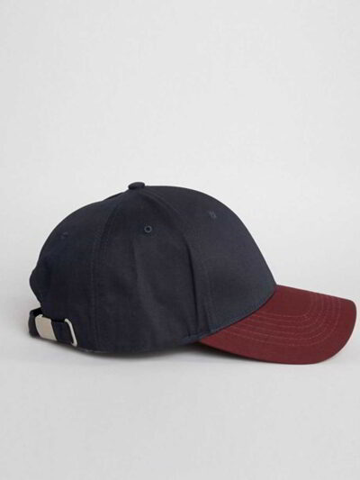 Close-up of a textured twill golf visor in navy with crisp white custom logo embroidery. Curved brim, detailed stitching, adj