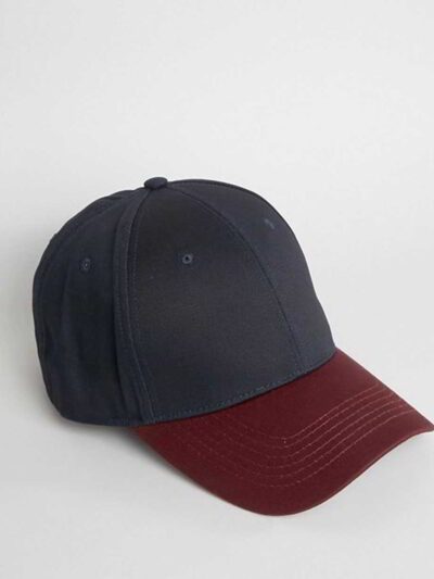 Close-up of a textured twill golf visor in navy with crisp white custom logo embroidery. Curved brim, detailed stitching, adj
