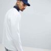 Long sleeve rugby shirt in deep navy with subtle textured weave. Custom logo stitching visible on chest. Durable, classic cor