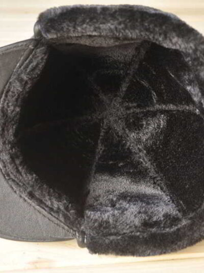 Leather driving cap with plush fleece lining. Warm winter hat, flat style, ear flaps. Fine stitching detail visible on smooth