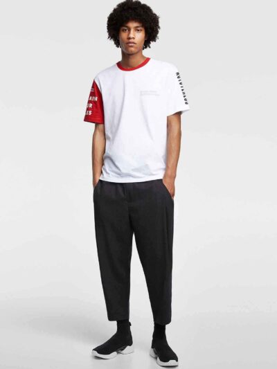 Men's crewneck tee showing custom design area. Soft cotton texture, reinforced stitching. Solid color backdrop highlights per