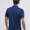 Close-up: Navy blue men's polo shirt. Soft pique knit texture, clean stitching. Classic short sleeves, subtle collar, custom