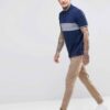 Close-up: Navy blue men's polo shirt. Soft pique knit texture, clean stitching. Classic short sleeves, subtle collar, custom