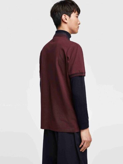 Close-up of a cotton polo shirt, showcasing fine pique knit texture and clean stitching. Casual top with subtle color variati