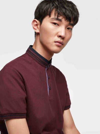 Close-up of a cotton polo shirt, showcasing fine pique knit texture and clean stitching. Casual top with subtle color variati