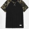 Men's camo raglan top. Contrasting stitching highlights patchwork. Soft, textured fabric. Casual style with earthy green and