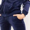 Navy velour tracksuit. Close-up shows plush velvet texture, zip-front hoodie, ribbed cuffs. Luxurious and comfortable. - View