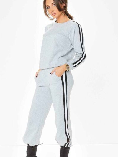 Grey women's tracksuit with sporty white side stripes. Soft knit texture, tailored fit. Activewear set for workouts or loungi