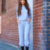 Grey women's tracksuit with sporty white side stripes. Soft knit texture, tailored fit. Activewear set for workouts or loungi