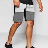 Close-up of charcoal sweat shorts featuring a raised, detailed embroidered logo. Soft, looped-back cotton fabric. Premium sti