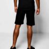 Close-up of charcoal sweat shorts featuring a raised, detailed embroidered logo. Soft, looped-back cotton fabric. Premium sti