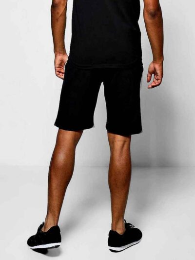 Close-up of charcoal sweat shorts featuring a raised, detailed embroidered logo. Soft, looped-back cotton fabric. Premium sti