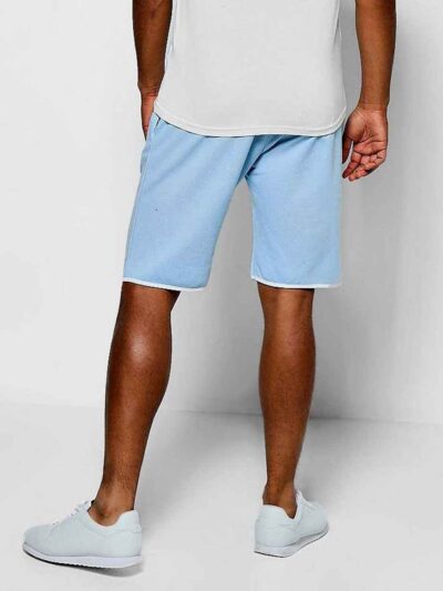 Luxury streetwear shorts, close-up. Black heavy cotton blend, rhinestone logo detail, reinforced stitching. High-end design.
