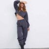 Women's running tracksuit set. Close-up on soft, slightly textured fabric. Zip-up jacket with pink trim. Comfortable fit for