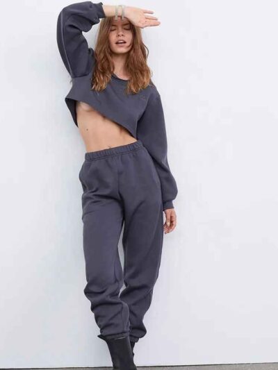 Women's running tracksuit set. Close-up on soft, slightly textured fabric. Zip-up jacket with pink trim. Comfortable fit for