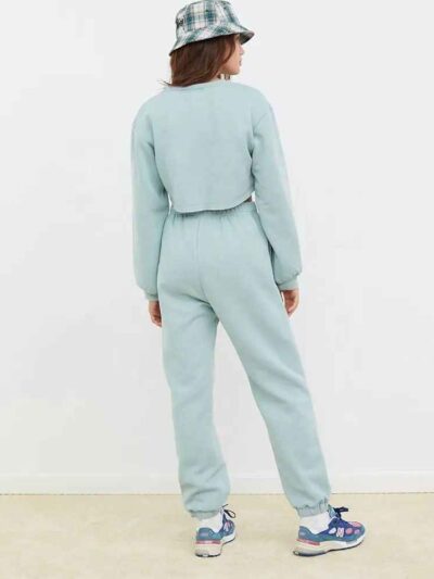 Women's running tracksuit set. Close-up on soft, slightly textured fabric. Zip-up jacket with pink trim. Comfortable fit for