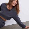 Women's running tracksuit set. Close-up on soft, slightly textured fabric. Zip-up jacket with pink trim. Comfortable fit for