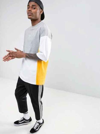 Oversized t-shirt with color block panels and embroidered text. Close up shows soft texture, quality stitching, and relaxed f