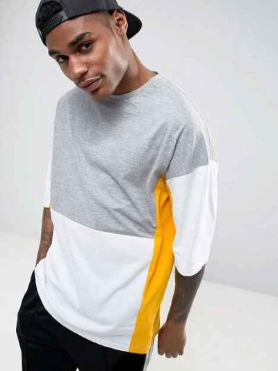 Oversized t-shirt with color block panels and embroidered text. Close up shows soft texture, quality stitching, and relaxed f