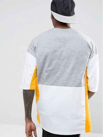 Oversized t-shirt with color block panels and embroidered text. Close up shows soft texture, quality stitching, and relaxed f