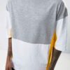 Oversized t-shirt with color block panels and embroidered text. Close up shows soft texture, quality stitching, and relaxed f