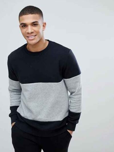Black and grey crew neck sweatshirt, ribbed knit texture, patch detail. Relaxed fit, visible stitching, ideal for layering. -