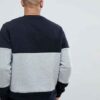 Black and grey crew neck sweatshirt, ribbed knit texture, patch detail. Relaxed fit, visible stitching, ideal for layering. -