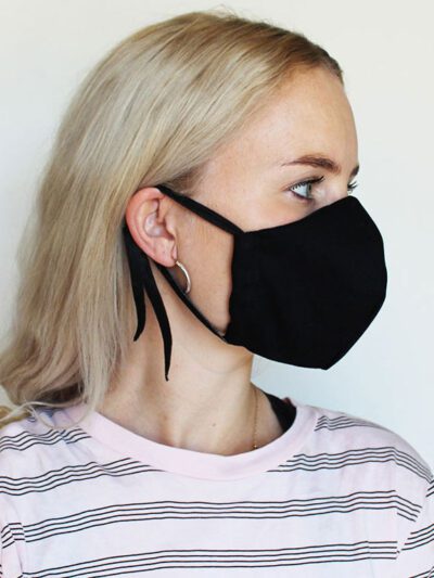 Reusable face mask, soft fabric, visible stitching detail. Breathable medical-style mask, adjustable ear loops for snug fit.