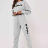 Gray lounge joggers, soft knit, close-up on textured fabric. Relaxed fit, cuffed ankles. Quality stitching visible on seams.