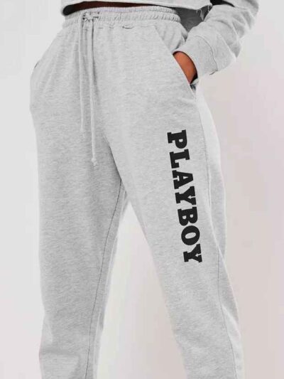 Gray lounge joggers, soft knit, close-up on textured fabric. Relaxed fit, cuffed ankles. Quality stitching visible on seams.